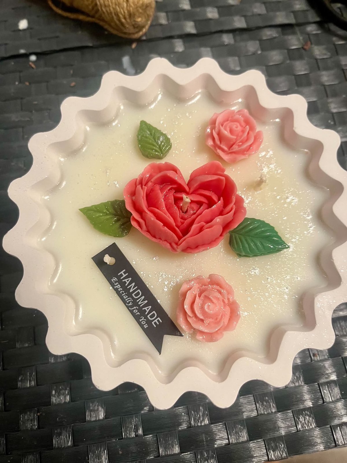 Ręcznie robiony tort dekoracyjny z białą falistą masą i różowymi różami z fondantu